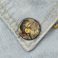 Close-up of a vintage frog playing guitar mushroom pin badge on light blue denim fabric - Frog Playing Guitar (XZ996)