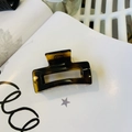 Detail of a large amber tortoiseshell hair claw clip with a transparent acrylic finish - Glossy Light Tortoise