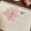 Dettaglio orecchino a fiore in tessuto rosa con perla su un vassoio in tessuto neutro - Rosa