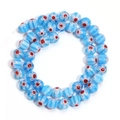 Macro shot of sky blue Millefiori glass beads with striped patterns and floral details - Lake Blue Red Flower