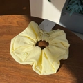 Detailed close-up of cream scrunchie fabric texture with button detail and hanging tag - Cream Yellow Button Puff Scrunchie Large