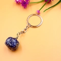 Blue and white natural stone keychain with wire-wrapped crystal pendant on orange background - Blue Sodalite