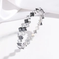 Macro shot of silver-tone steel bangle featuring black and white square-cut cubic zirconia - Black