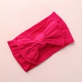 Close-up detail of hot pink cable knit baby headband featuring a large bow decoration - Rose Red