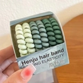 Set of spiral hair ties in gradient green shades housed in a branded display box - Green Series/Wild Field