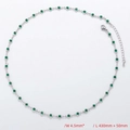 Detail view of silver chain necklace with circular green stones and lobster clasp closure - Necklace / Platinum / Green Zirconia