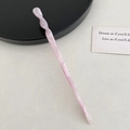 Vue détaillée d'une épingle à cheveux rose torsadée en acétate sur un fond beige épuré - Forme Torsadée / Rose Pourpre