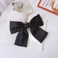 Oversized black matte satin bow hair clip with vintage French style on a book - Big Bow Spring Clip / Black