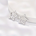 Minimalist silver star earrings with polished hollow design on a white satin stand - Silver