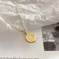 Minimalist gold necklace with abstract face pendant on an artistic paper background - Portrait Round Plate