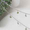 Macro view of silver plated chain featuring round green rhinestone pendant charms - Silver Chain - Green Stone