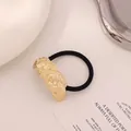 Minimalist elastic hair tie with golden lava-textured metal piece measuring 5x2cm - Twist Pattern Gold