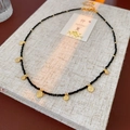 Macro detail of black beaded necklace with vintage golden circular embossed charms - Necklace-Gold-Black