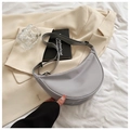 Detail view of a gray nylon crescent shoulder bag placed on a neutral lifestyle background - Gray