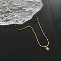 Collana con ciondolo a perla dorata stile vintage e catena a grani su sfondo nero - Viola