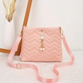 Detail of pink quilted crossbody bag featuring a cute pearl cat pendant and adjustable strap - Pink