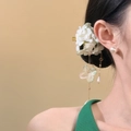 Close-up detail of white fabric flower hair clip with elegant long pearl tassels on model - Duckbill Clip - Single Piece / Green