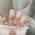 Uñas postizas con estampado de leopardo, lazos negros y acabado nude en manos elegantes - S / 10 Piezas