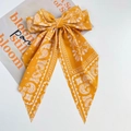 Dettaglio del fiocco per capelli giallo con motivo paisley e nastri lunghi in chiffon - Giallo Stampa Paisley Nastro