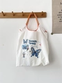 Detail of white canvas tote with blue butterfly print and orange woven rope handles - Floral Butterfly White