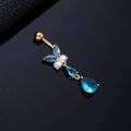 Macro shot of gold butterfly belly ring with blue and white zircons on black mirror - Blue Butterfly Gold