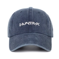 Close-up of the HUNTR/X white embroidery on a navy washed denim baseball cap - Navy Blue