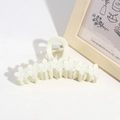 Detailed view of a white flower-shaped hair claw clip for elegant hairstyles - Beige