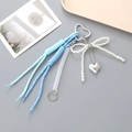 Détail du cordon tressé bleu, nœud en perle et breloque cœur avec anneau en forme de cœur - Bleu Clair/Bleu