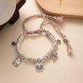 Macro detail of hand-woven bracelet with silver charms and Peace sign pendant - L393-6 Yellow Wealth God (Pink-Green Rope)