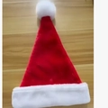 Classic red plush Christmas hat with white faux fur trim on a wooden tabletop - Double Layer Lined Red Short Plush Baby / Red/White