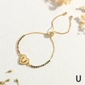 Nahaufnahme des goldenen Herzanhängers mit Buchstabe U und bunten Zirkonia auf Kette - Buchstabe U