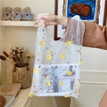 Dettaglio del delicato ricamo floreale giallo sulla borsa a mano in tulle bianco - Giallo