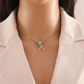 Detailed view of a gold-finish necklace with blue bead and letter A pendant on a model - Letter A (N1339)