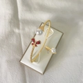 Elegant gold bangle featuring a red zircon butterfly and white pearls in variant finish - G Red