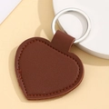 Close-up of a brown heart-shaped leather keychain with silver metal ring and fine stitching - Heart Shape / Dark Coffee