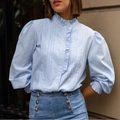 Detail van elegante pofmouwen en delicate ruches op een lichtblauwe blouse - S / Blauw