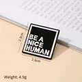 Pin cuadrado de esmalte en blanco y negro con el eslogan motivador Be A Nice Human - Broche BE A NICE HUMAN