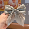 Gray glossy fabric bow hair clip held by hand showing the school style hair accessory - Mermaid Shimmer Green