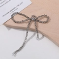 Macro shot of smoky grey crystal bow charm with delicate dangling tassels for DIY jewelry - Gray