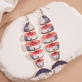 Detailaufnahme der beweglichen Fisch-Ohrringe aus Holz mit bunten Meeresmustern - Blau