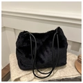 Close-up of soft black faux fur texture on a luxury tote bag atop a knit blanket - Black Without Pendant