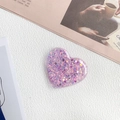 Detail of a purple heart-shaped phone grip with sparkling glitter and sequins on white texture - Glitter Heart - Clear Edition / Deep purple