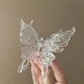 Pince à cheveux papillon liquide transparent pour coiffure élégante sur fond blanc pur - Pince Papillon Transparente