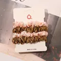 Detail view of 4-piece set of satin scrunchies in pink and champagne gold on card - Ivory and Gold