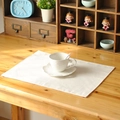 Creamy white linen placemat on wooden table with a white coffee cup and green plant - White