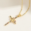 Dettaglio del ciondolo a croce dorata con zirconi multicolore e due cuori intrecciati - Croce Doppio Cuore