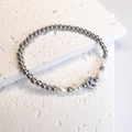 Detalle de pulsera de cuentas de acero inoxidable con perlas de agua dulce y dije luna - Luna y Estrella / Color Acero