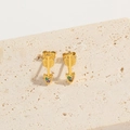 Arrow-shaped gold stud earrings with colorful zircon stones on a beige stone surface - Arrow (ES2644)