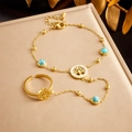 Gouden levensboom ringarmband met blauwe turquoise kralen op een champagne achtergrond - Levensboom (B1245)