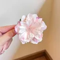 Pink and white mesh flower hair clip with layered gradient petals held by hand - Pink Camellia